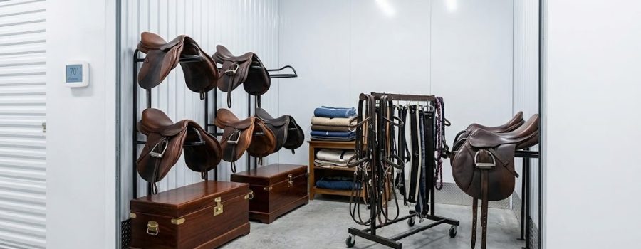 Climate-controlled Wellington Equestrian Storage unit with English saddles, wooden show trunks, and leather tack at Lake Worth Storage
